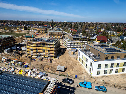 Mehrfamilienhäuser in Holz-Hybrid-Bauweise mit Gerüst, Photovoltaik auf Flachdächern