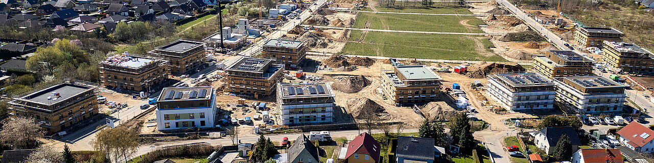Drohenansicht des Wohnungsbauprojekts Bisamstraße in Berlin-Mahlsdorf mit sichtbarem Baufortschritt, unterschiedliche Fertigstellungsstufen an 13 Häusern