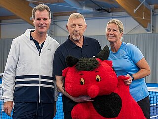 Gruppenfoto mit Boris Becker in der Tennishalle auf dem Spielfeld vor dem Netz